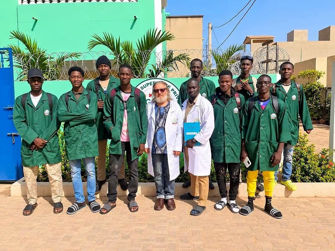 Une promotion d'étudiants en blouse verte et leurs encadrants devant le bâtiment d'AGRI'SUP.